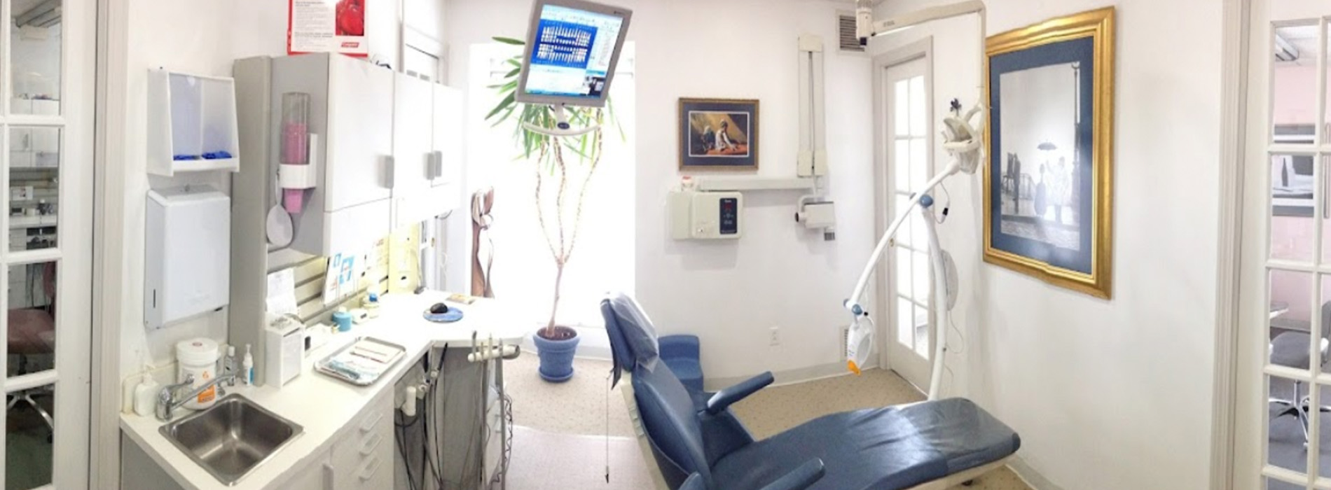 The image shows a modern dental clinic interior with various pieces of equipment, including a dental chair and an X-ray machine.